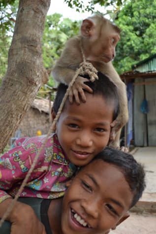Some local kids with a pet monkey